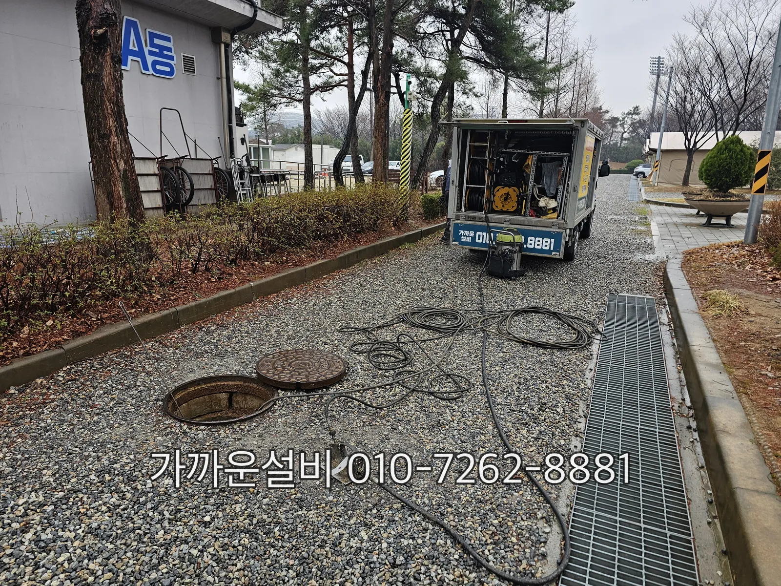 아파트 단지 옥외 맨홀을 열고 고압세척 호스를 연결한 모습